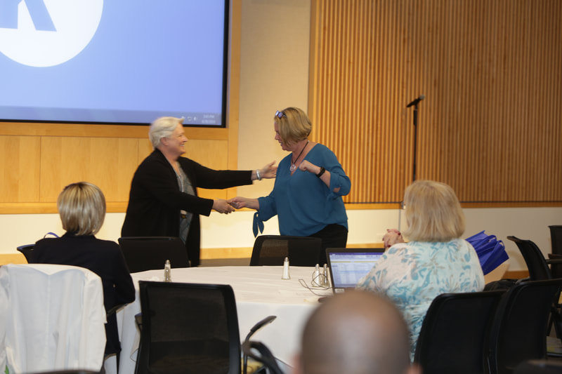 Darla Wilkerson executive director giving attendee door prize to woman